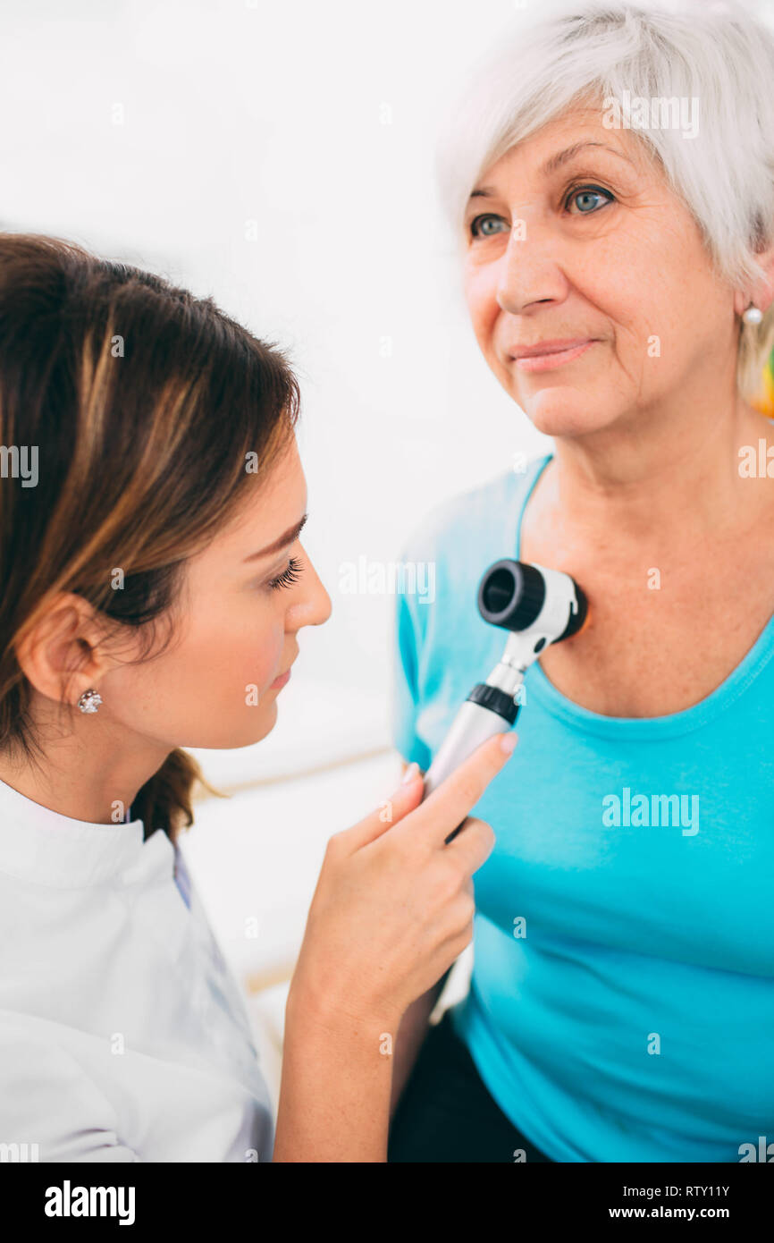 médecin examinant les grains de beauté de la peau du patient avec le dermoscope Banque D'Images