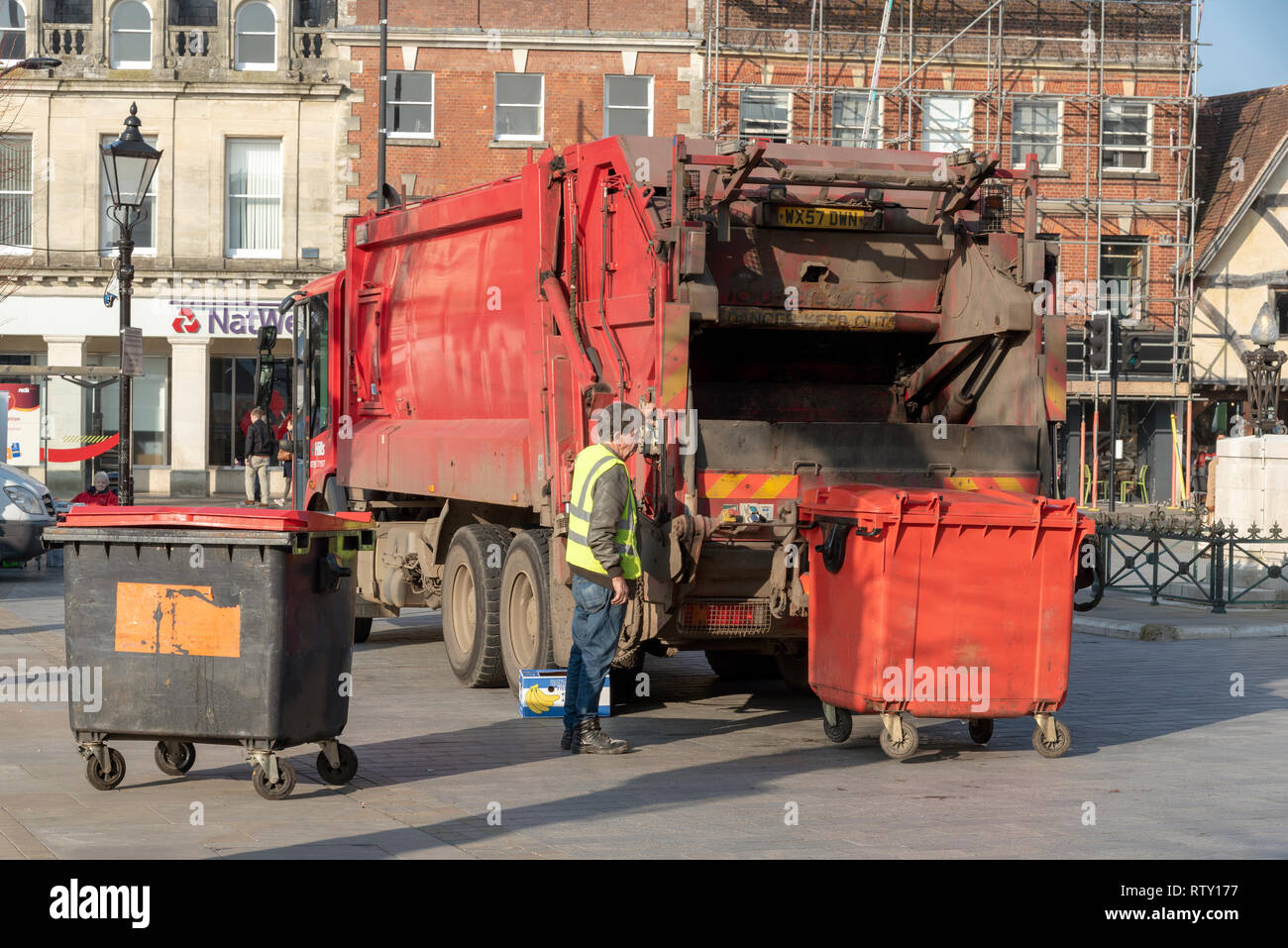 Salisbury, Wiltshire, Angleterre, Royaume-Uni. Février 2019. Le chargement d'une taille commerciale poubelle rouge dans un camion dans le centre-ville. Banque D'Images