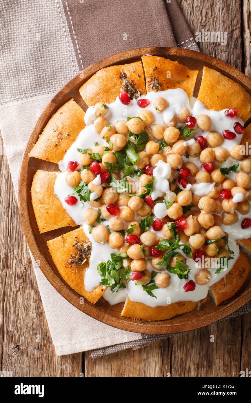 Fatteh libanais authentique est faite avec du yogourt, des pois chiches et de pain pita sur une plaque sur la table. Haut Vertical Vue de dessus Banque D'Images