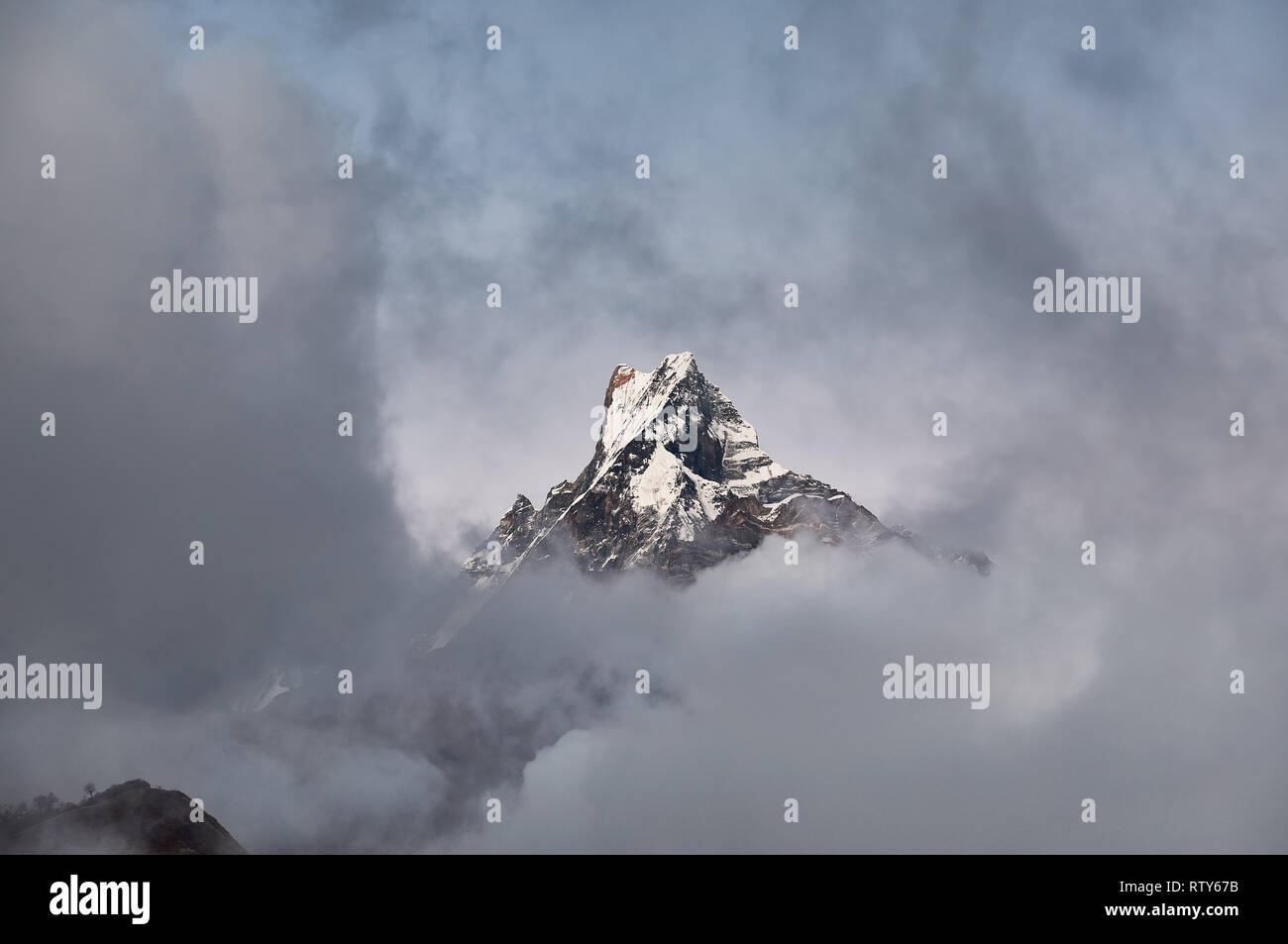 Poisson Machapuchare pic conte entouré de nuages dans l'Himalaya, au Népal. Banque D'Images Poisson Machapuchare pic conte entouré de nuages dans l'Himalaya, au Népal. Banque D'Images