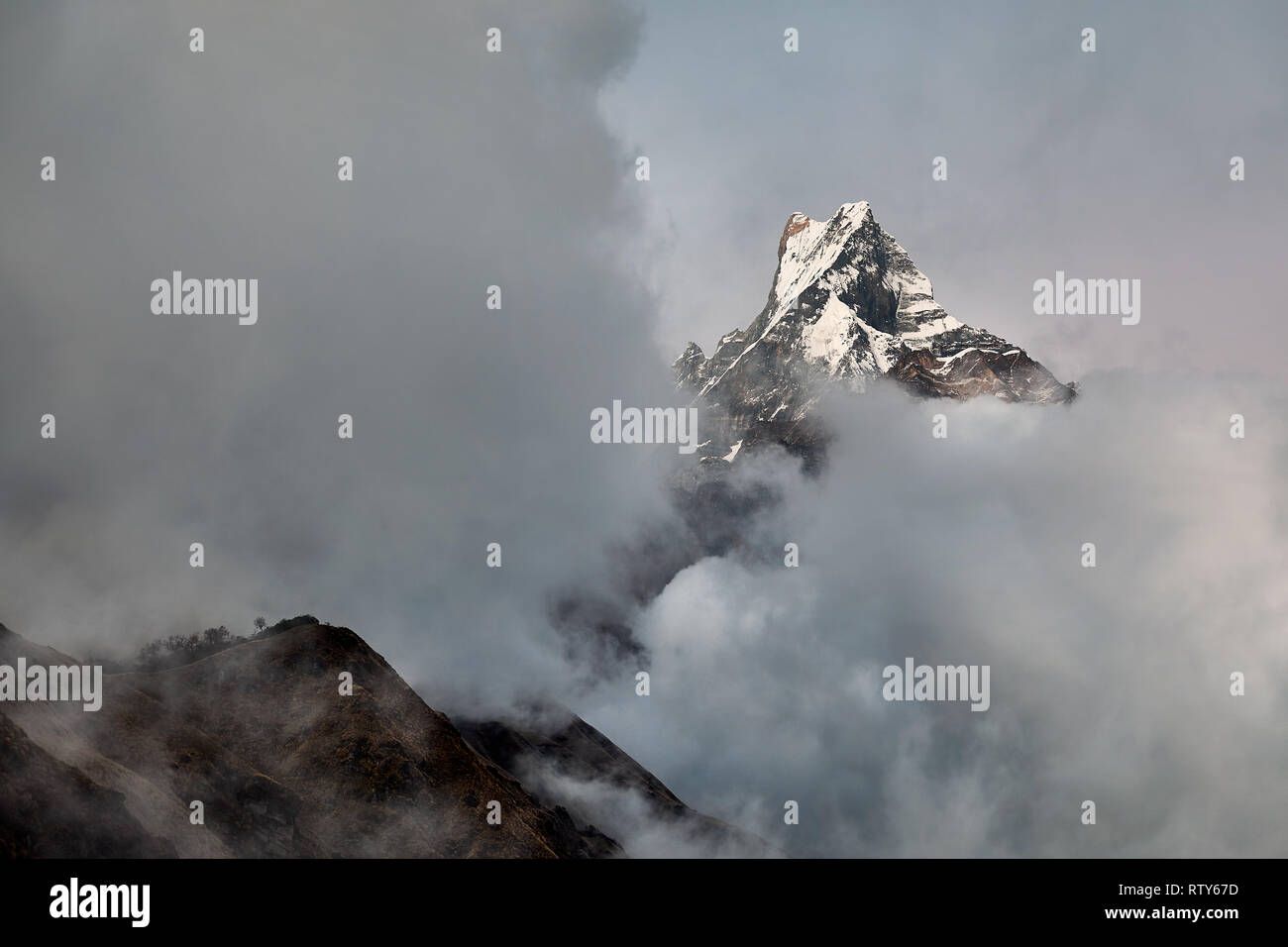 Poisson Machapuchare pic conte entouré de nuages dans l'Himalaya, au Népal. Banque D'Images Poisson Machapuchare pic conte entouré de nuages dans l'Himalaya, au Népal. Banque D'Images