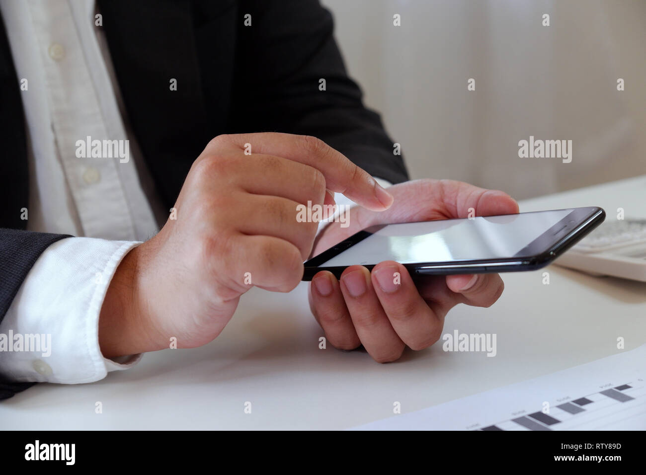 Businessman working in office à l'aide de téléphone mobile sur le bureau Banque D'Images