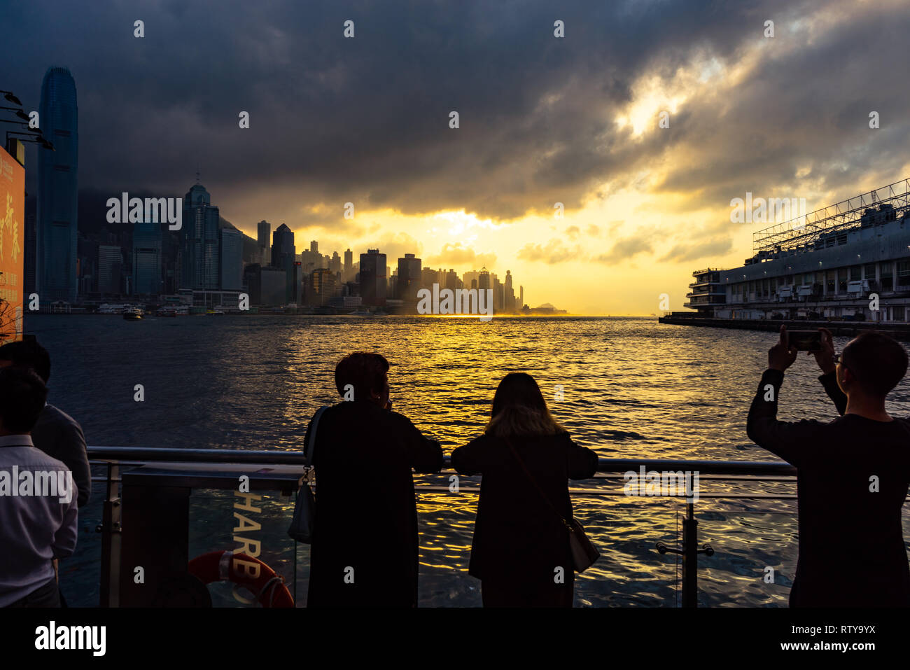 Les touristes voir magnifique coucher de soleil sur le port de Victoria et les toits de Hong Kong, Chine Banque D'Images