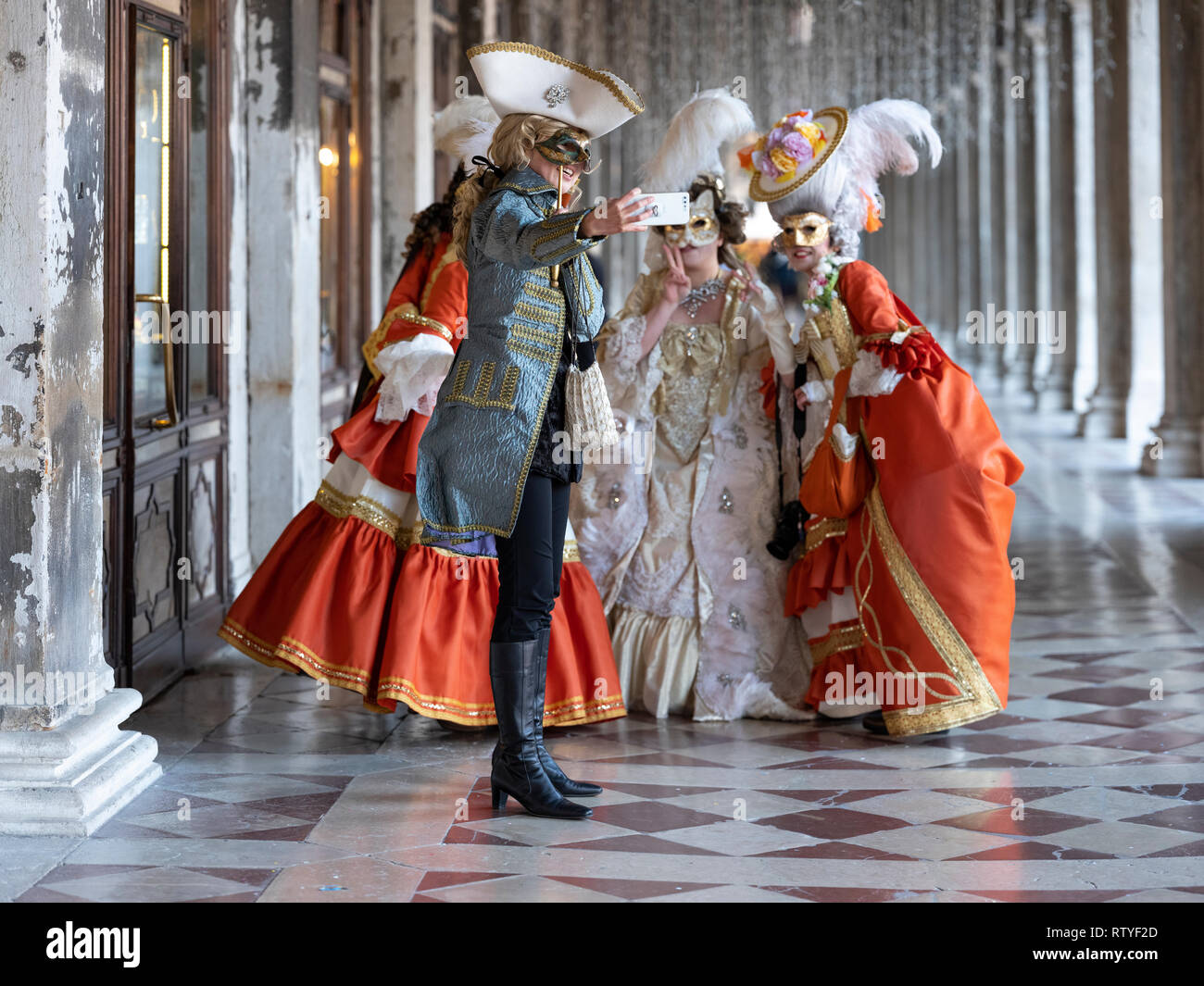 Un groupe de dames à la fête des masques de Venise ayant un groupe photographie prise avec un téléphone mobile Europe Italie Venise Banque D'Images