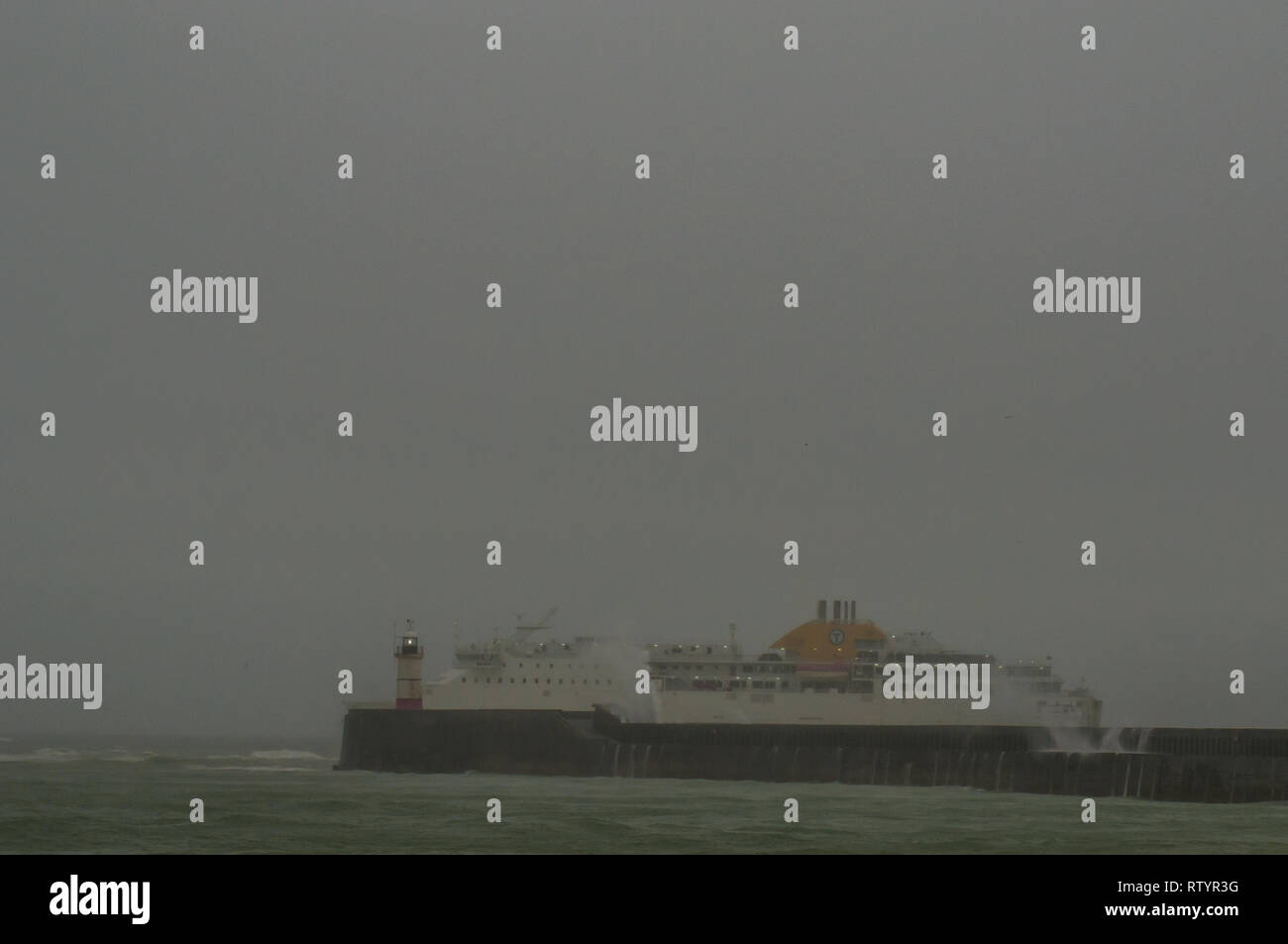 Newlaven, East Sussex, Royaume-Uni. 03ème mars 2019. Vent de la tempête Freya fouette des vagues le long du manteau sud de l'Angleterre. Le ferry de Transmanche à l'arrière part de l'entrée du port. Banque D'Images