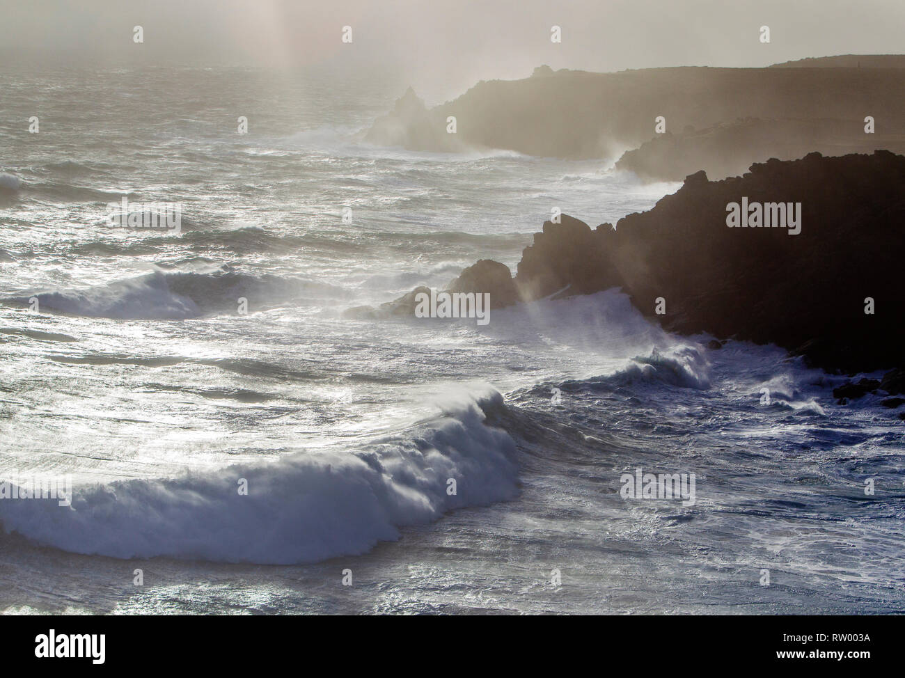 Sennen, Cornwall, UK. Le 3 mars 2019. Des coups de vent et des vagues hautes de 20 pieds lash le granite abruptes de Cornwall. Les cavaliers de l'audace de se faire prendre par des énormes vagues submergeant l'embarcadère. Crédit : Mike Newman/Alamy Live News. Banque D'Images