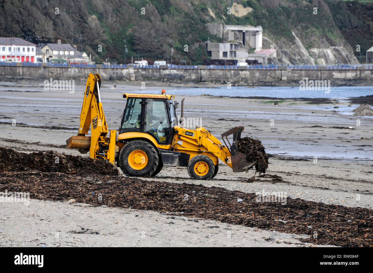 Un déménagement de la terre n tracteur sur le front de mer, déménagement d'algues dans Douglas dans l'île de Man, la Grande-Bretagne. L'île de Man avec sa capitale, Douglas J Banque D'Images