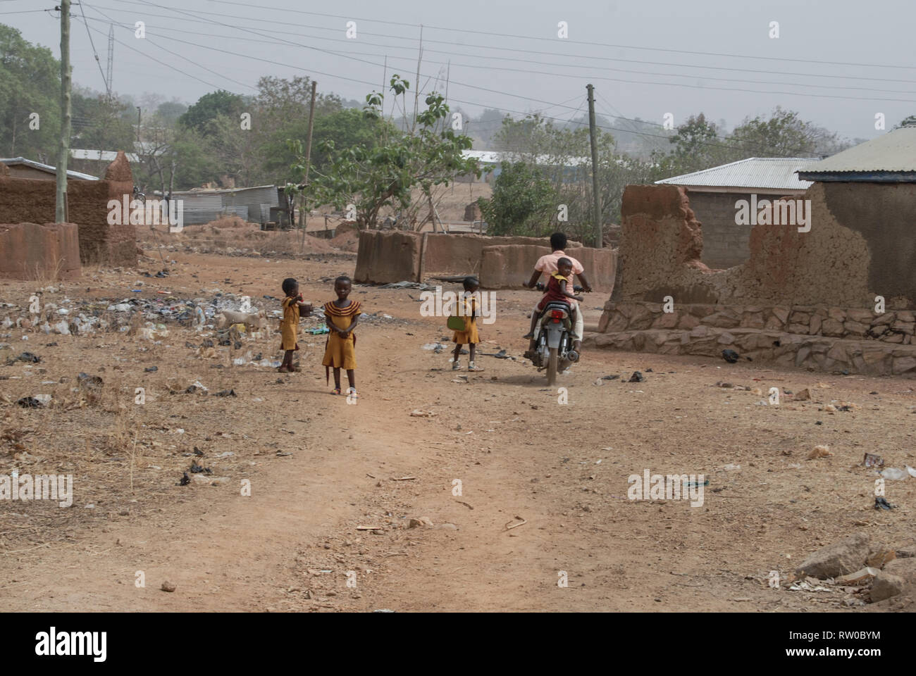 Une photo de l'école les enfants ghanéens marche sur une rue locale après une longue journée à l'école. Banque D'Images