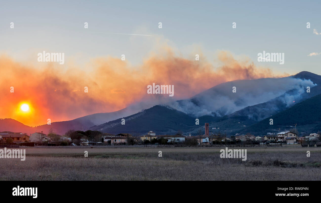 Vue panoramique sur le coucher de soleil sur une zone de forêt brûlée par un grand incendie à l'homme, Monte Pisano, Toscane, Italie Banque D'Images