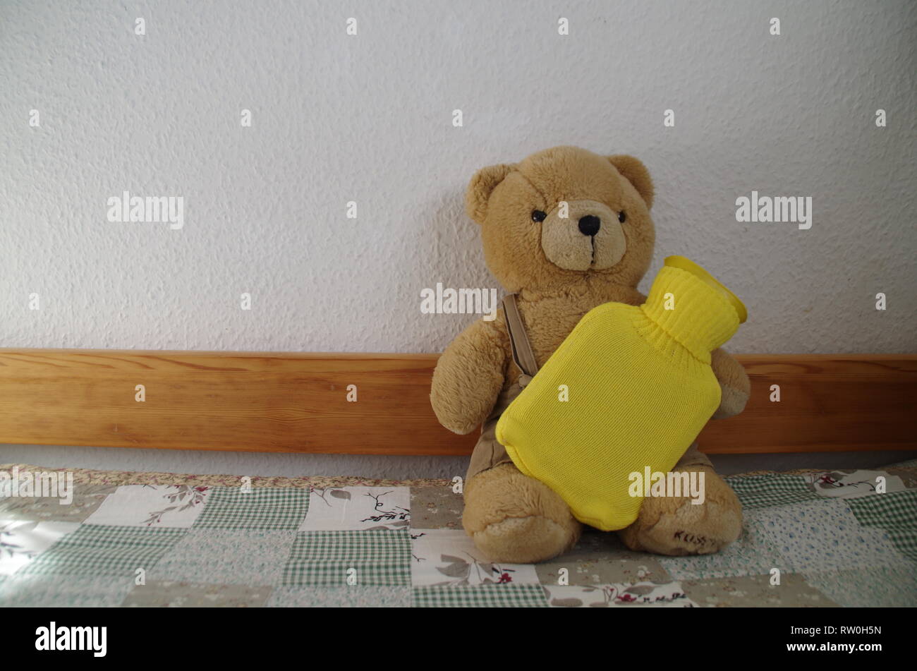 La douleur d'estomac - ours avec sac jaune de l'eau chaude Banque D'Images