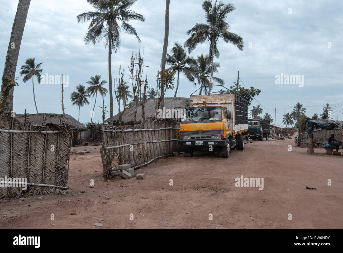 Un camion jaune garée à une rue d'une banlieue de ville tropicale de Elmina, Ghana Banque D'Images