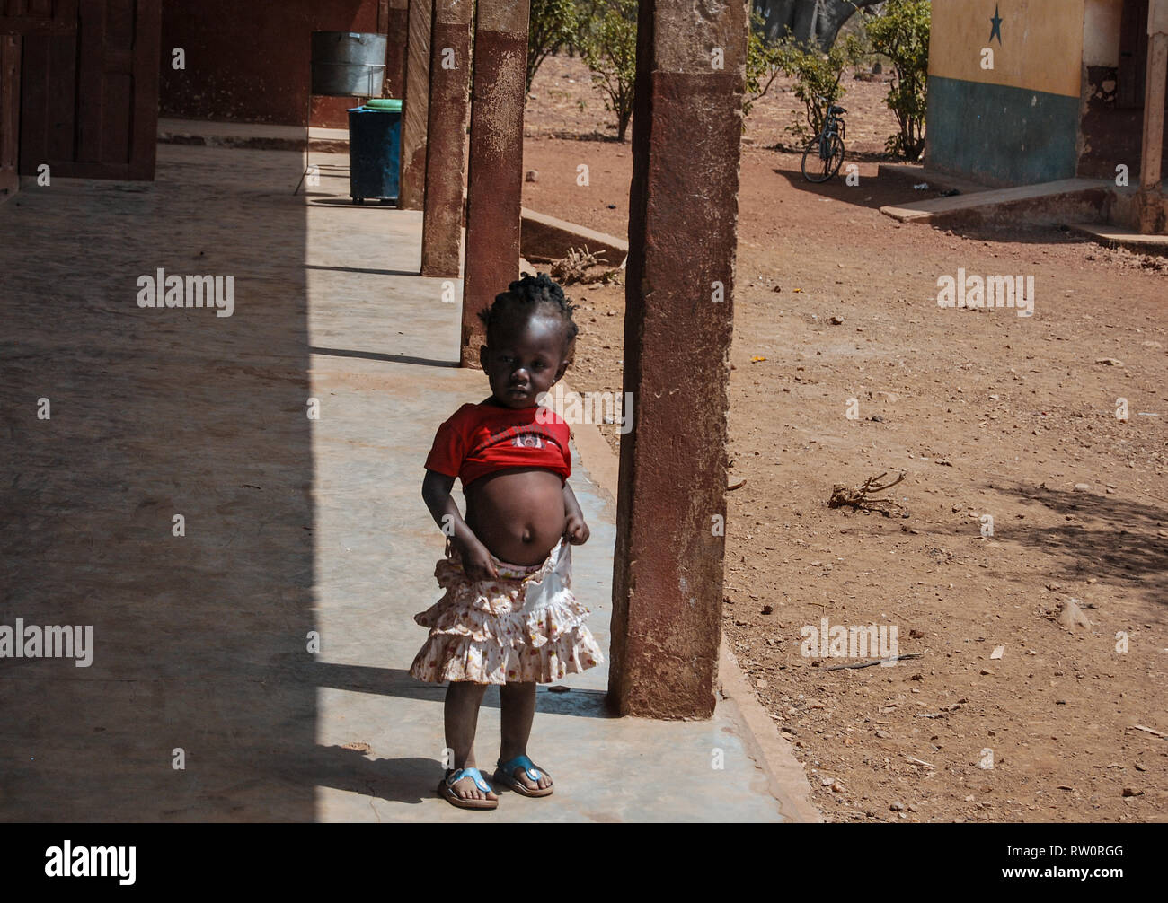 Une photo d'une belle fille ghanéens portant un t-shirt et une jupe en montrant son mannequin sur une rue de village local. Banque D'Images