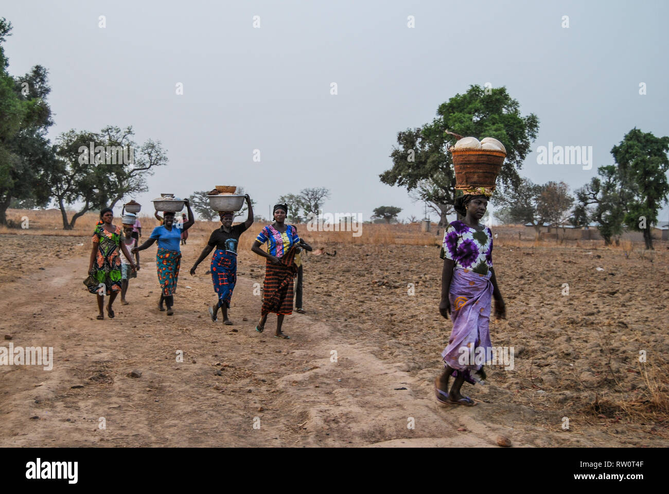 Les femmes ghanéennes portant des vêtements traditionnels sont d' aller au marché pour vendre leurs produits de boulangerie et autres. Les articles sont transportés sur la tête. Banque D'Images