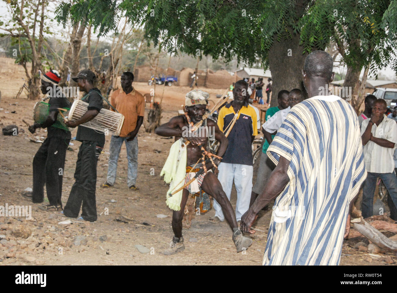 Les hommes portant des vêtements traditionnels ghanéens mélangé avec de modernes effectuant une danse rituelle à l'honneur du défunt à un salon funéraire Banque D'Images
