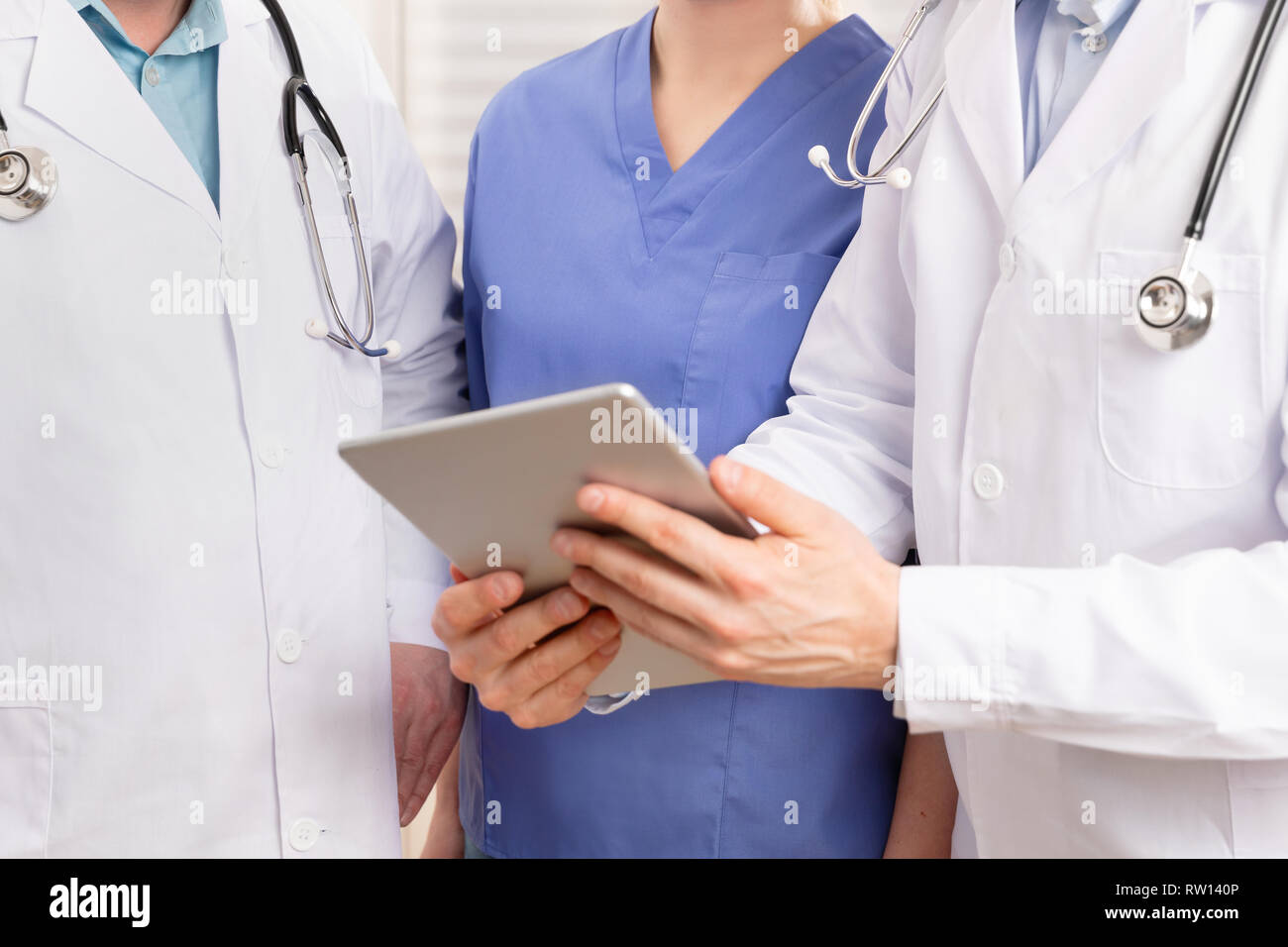 L'équipe médicale Médecin et discuter le rapport patient à tablet computer in hospital Banque D'Images