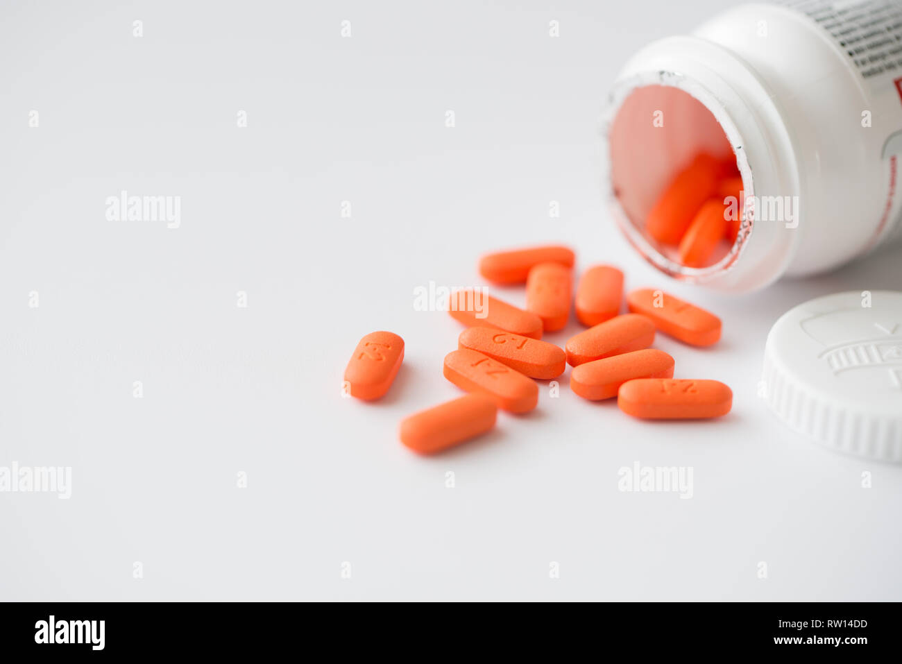 Comprimés orange blanc bouteille en cascade Banque D'Images