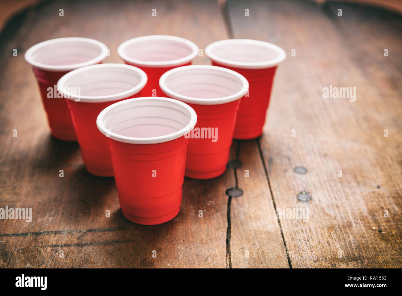 Beer Pong, college party game. Couleur rouge en plastique tasses dans une forme de triangle sur fond de bois Banque D'Images