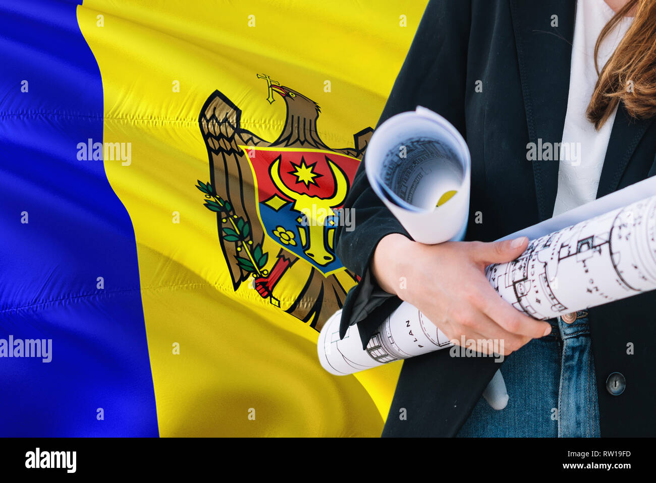 Architecte moldave woman holding blueprint contre Moldova waving flag background. Construction et architecture concept. Banque D'Images