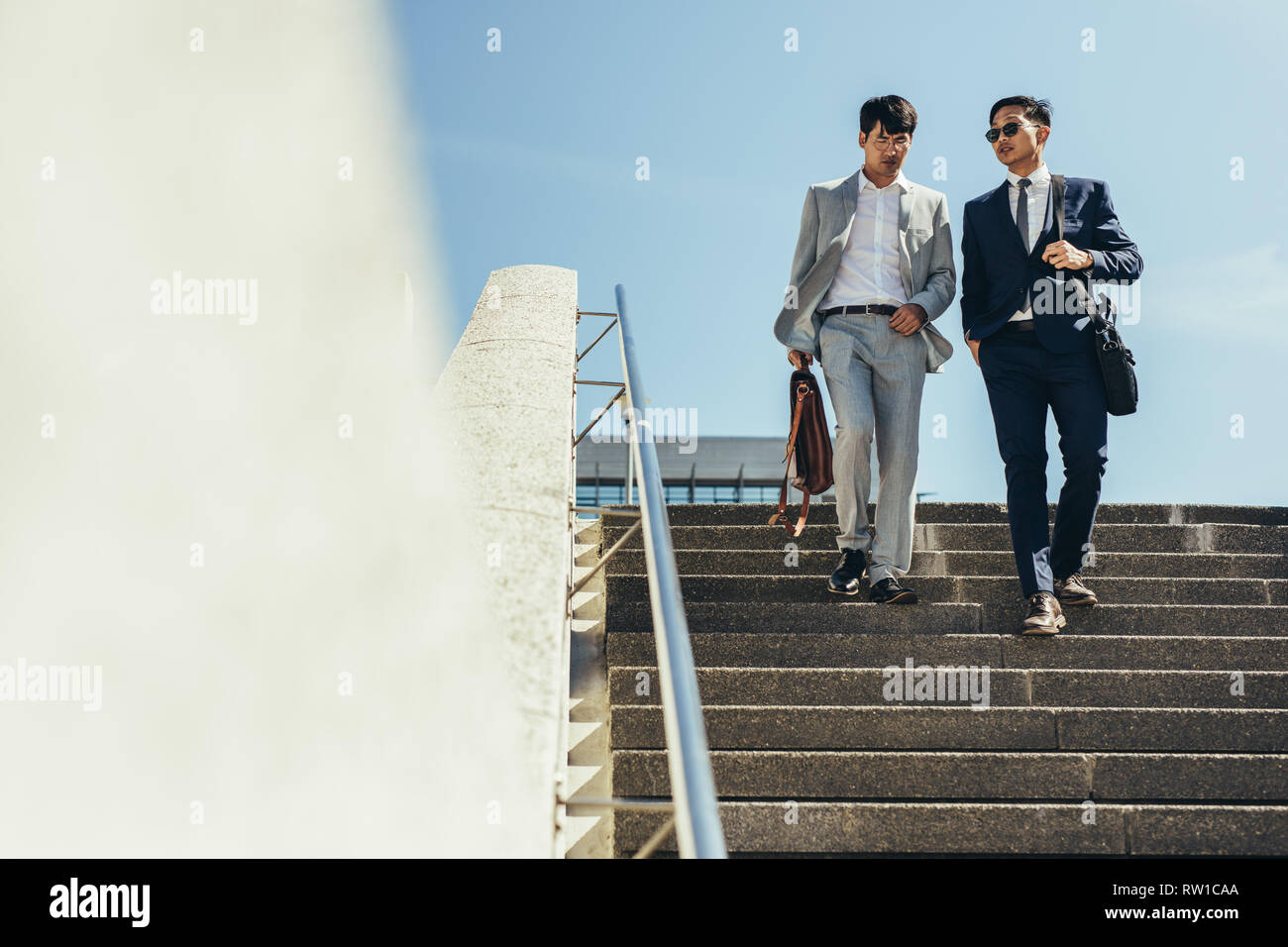 Deux personnes descendant des escaliers. Les hommes d'affaires coréens parler et marcher dans les étapes. Banque D'Images