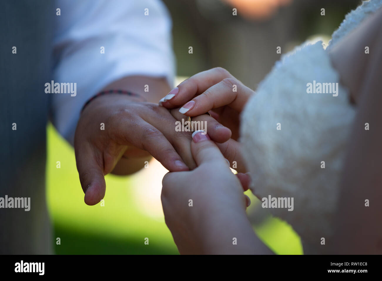Anneau de mariage mariée mettre sur le doigt du marié pendant la cérémonie de mariage Banque D'Images