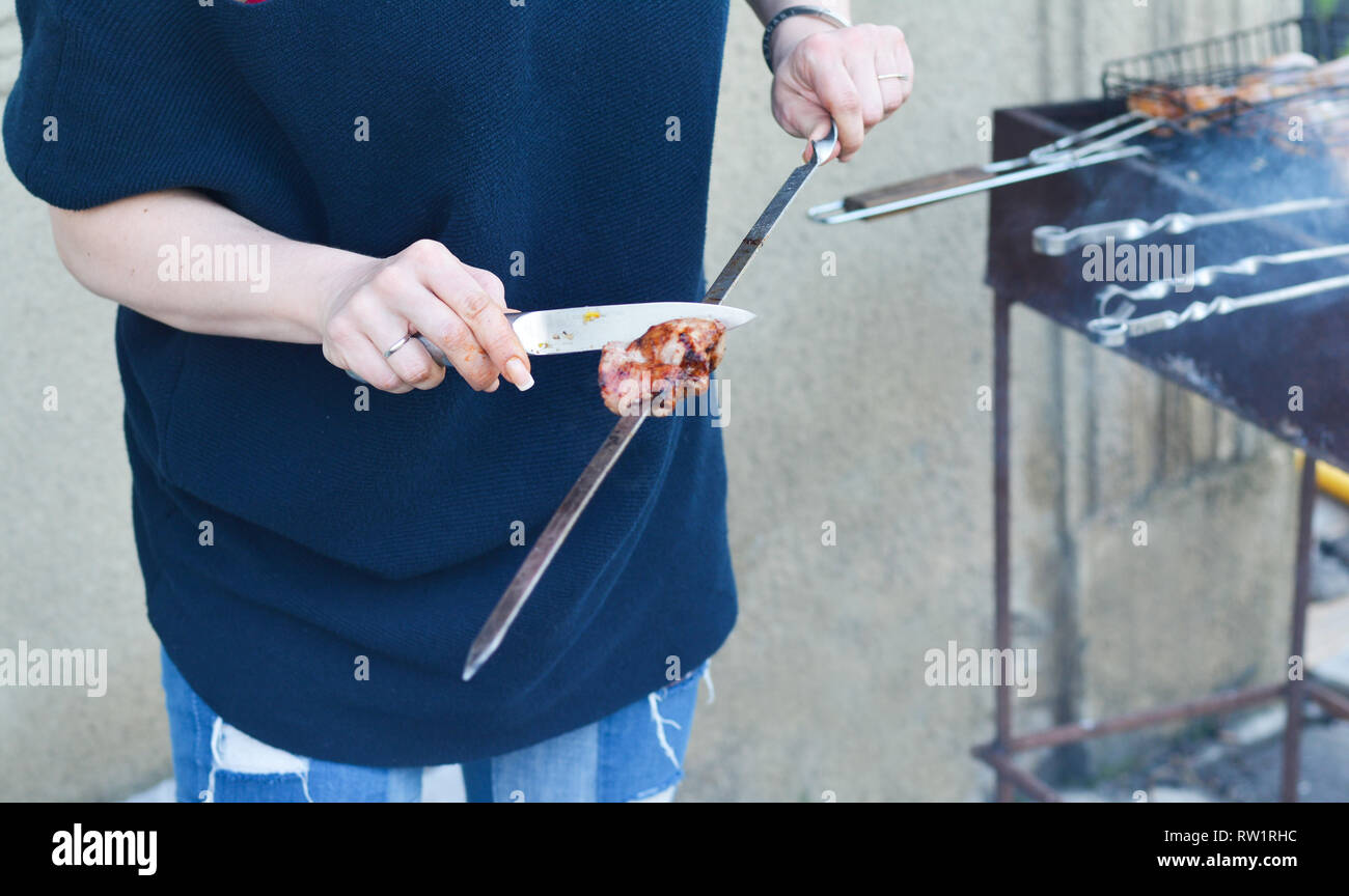 Women's Hands cut barbecue brochette de viande sur le grill Banque D'Images