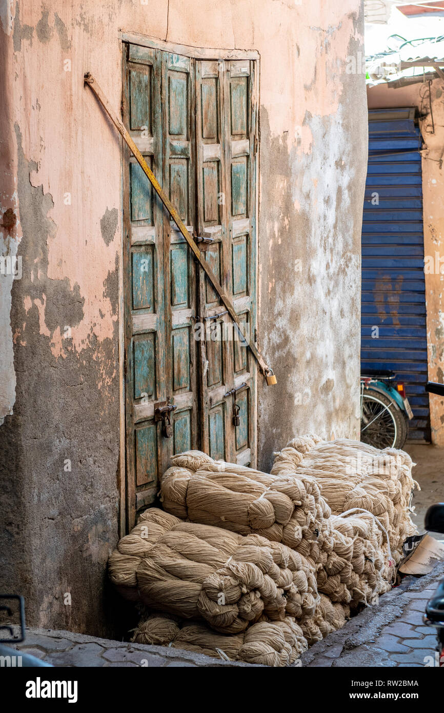 Les faisceaux de fils reste empilé devant porter porte dans médina de Marrakech, Maroc Banque D'Images