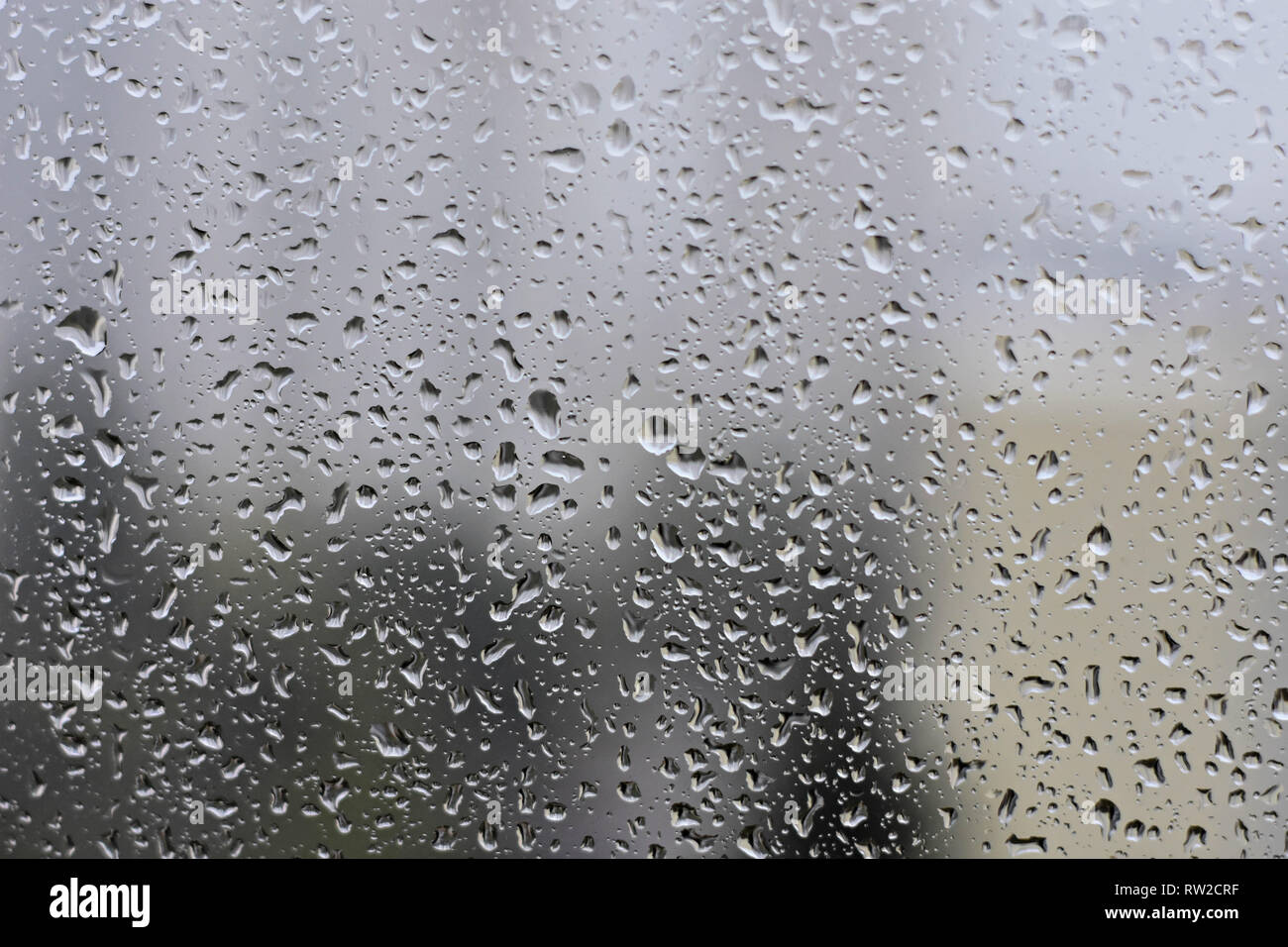 Gouttes de pluie sur les vitres à l'arrière-plan flou jour de pluie à l'extérieur bleu ciel nuage - Image de texture Banque D'Images