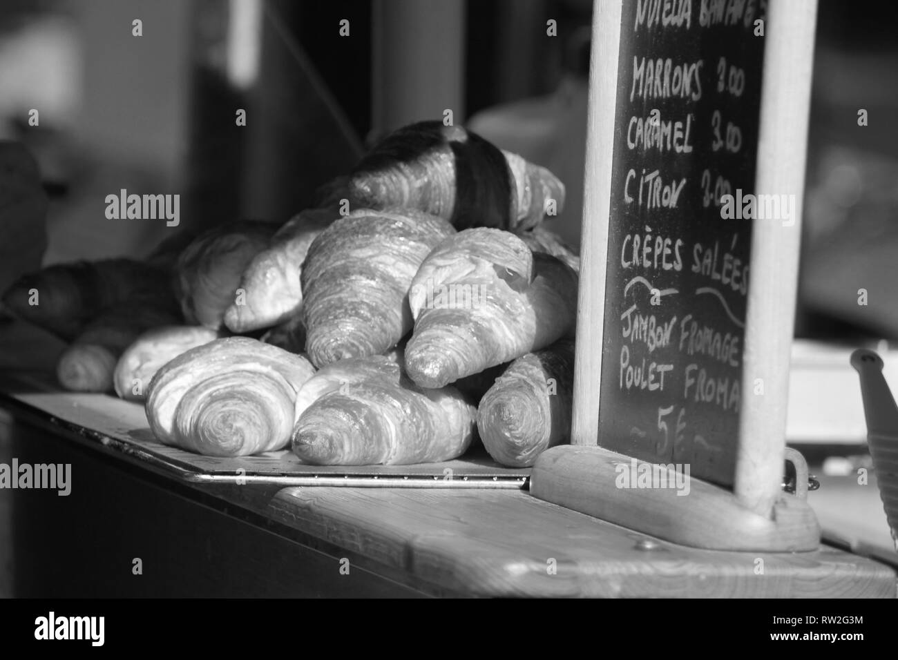 Paris France noir et blanc artistique des croissants dans le soleil au café Banque D'Images