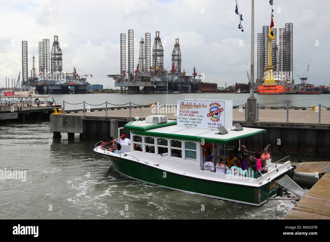 GALVESTON, Texas, USA - 9 juin 2018 : les touristes sur un bateau d'Excursion Dolphin Baywatch dans le Port de Galveston. Dans l'arrière-plan de forage pétrolier. Banque D'Images