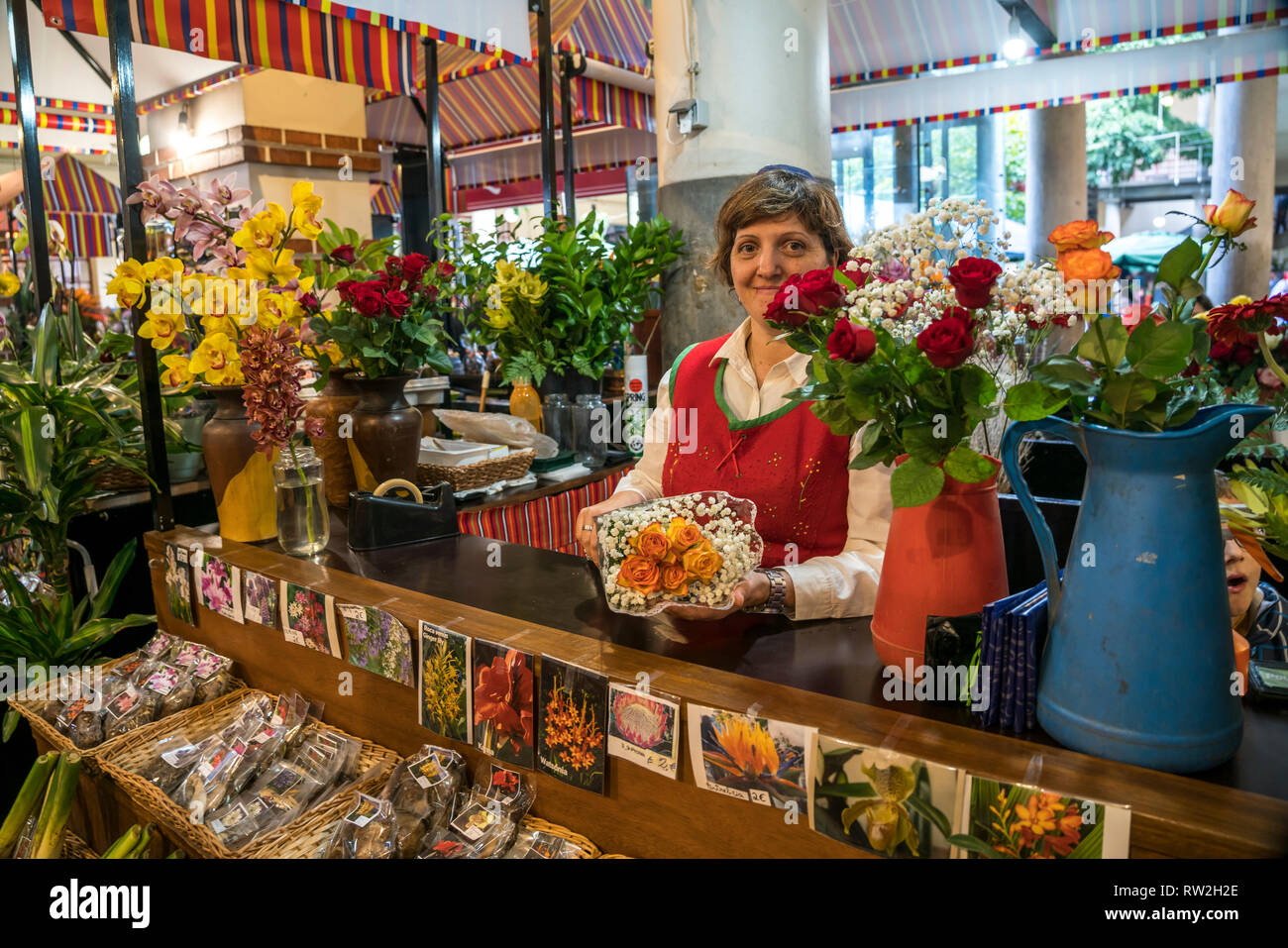 Verkäuferin mit Blumen in der Markthalle mercado dos Lavradores à Funchal, Madère, Portugal, Europa | vente femme avec des fleurs à la halle Banque D'Images