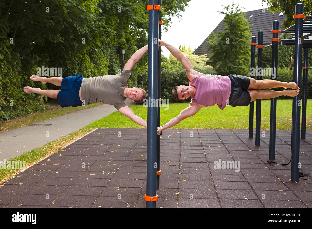 Les jeunes athlètes montrant drapeau humain, au cours de street workout pour la maîtrise du corps à l'extérieur sur une journée d'été. Banque D'Images