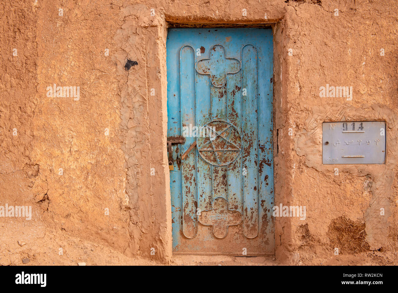 De l'extérieur en pisé traditionnel construit avec porte bleue avec Pentagram, trouvés au Maroc drapeau, Oasis Tighmert, Maroc Banque D'Images