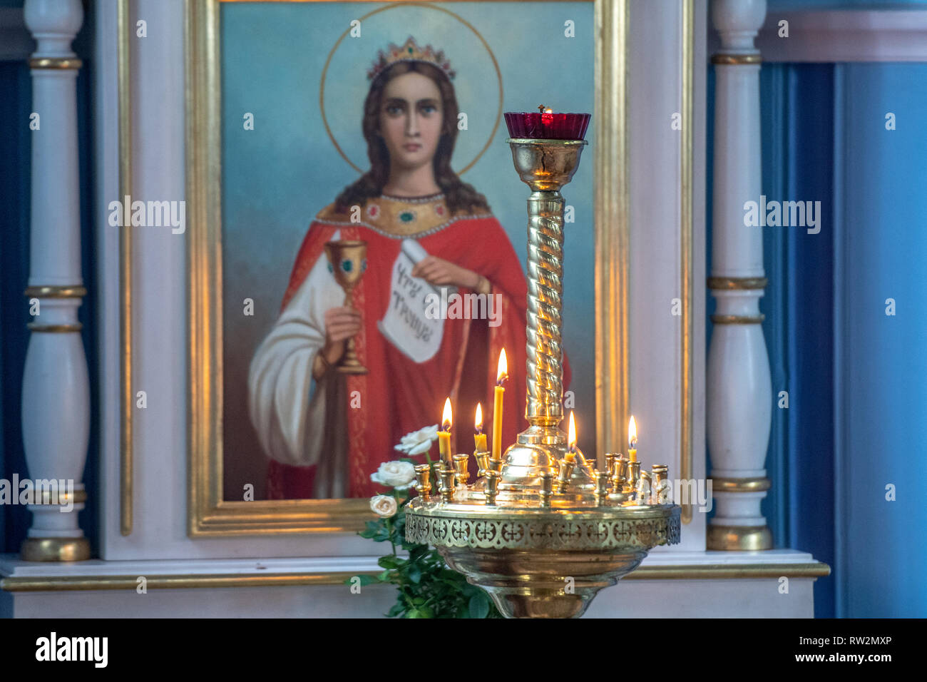 Allumer des bougies brûler sur l'autel avec peinture représentant Christian icône religieuse derrière elle dans l'Église orthodoxe russe (prawosławna Parafia pw. Straży Pożarnej Matk Banque D'Images