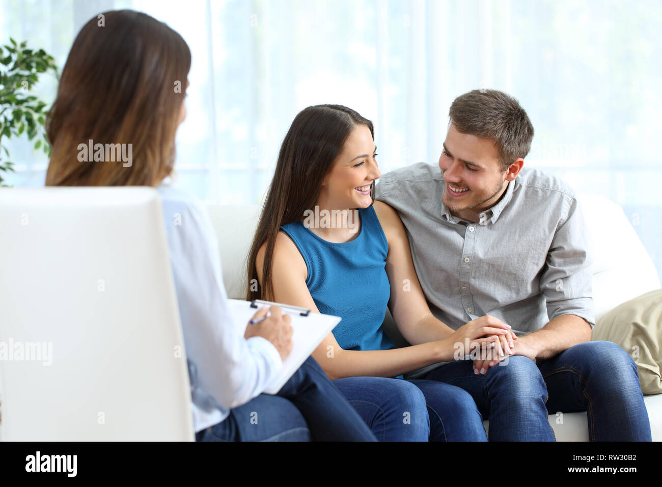 Mariage heureux après la thérapie de couple assis sur un canapé à la maison ou de consultation Banque D'Images