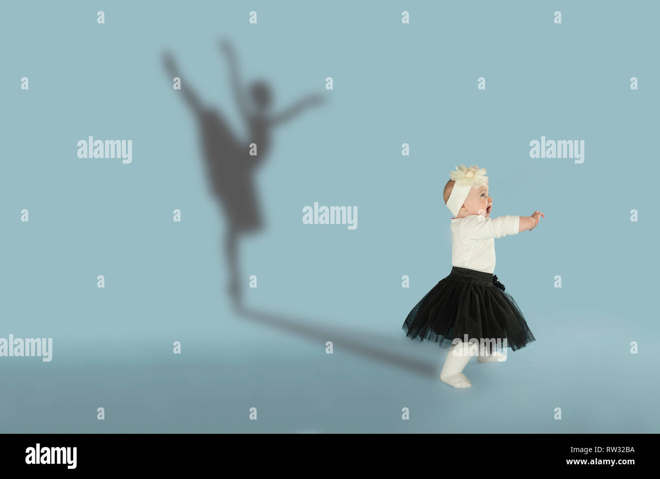 Petite fille à rêver de danser le ballet. L'enfance et de l'dream concept. Image conceptuelle avec l'ombre de ballerine sur le mur de studio Banque D'Images