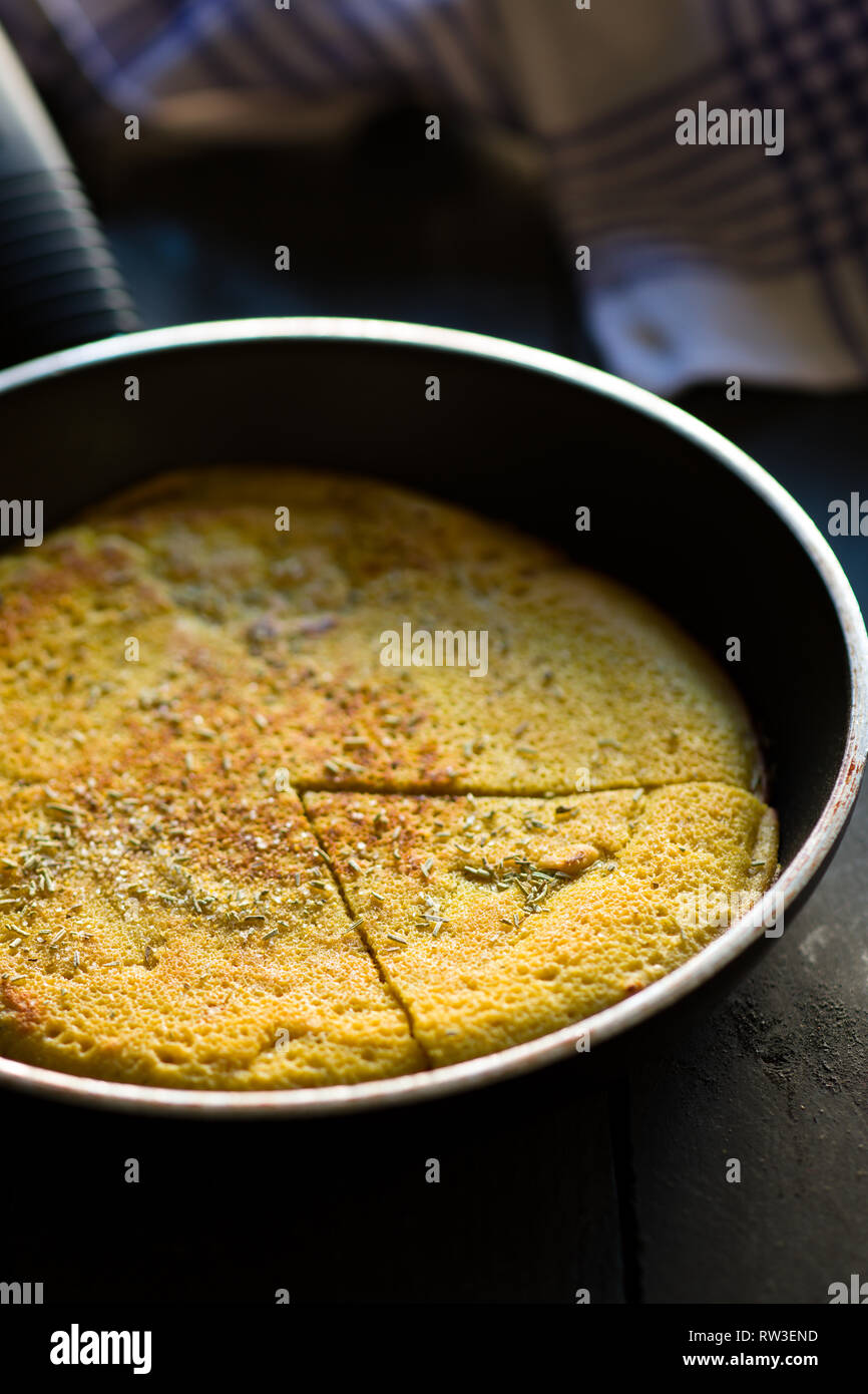 Pois chiches Vegan tranchés omelette sur une poêle Banque D'Images