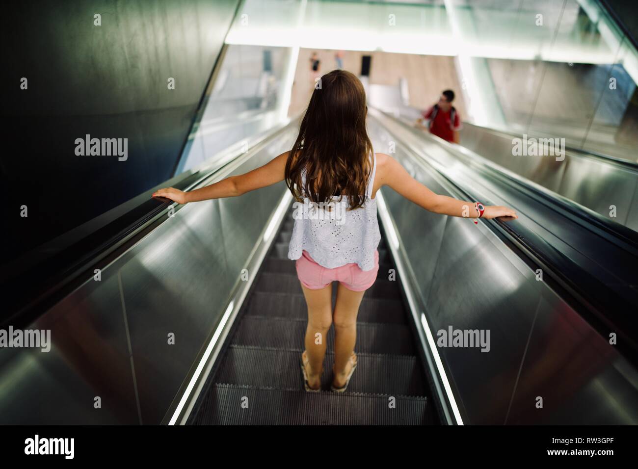 Jeune fille en descendant l'escalator, London Underground, 'Le Tube' fond argenté Banque D'Images