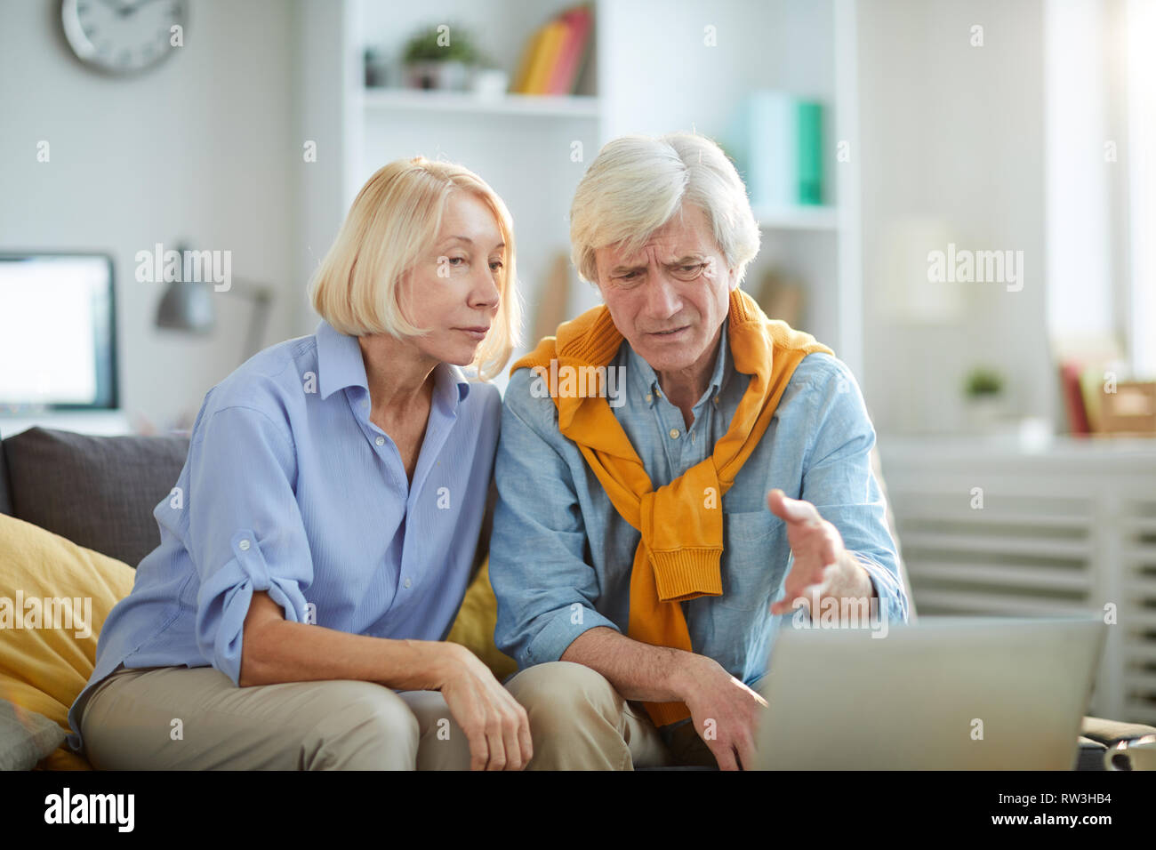 Portrait de couple contemporain à la recherche à l'écran d'ordinateur et de froncer, copy space Banque D'Images