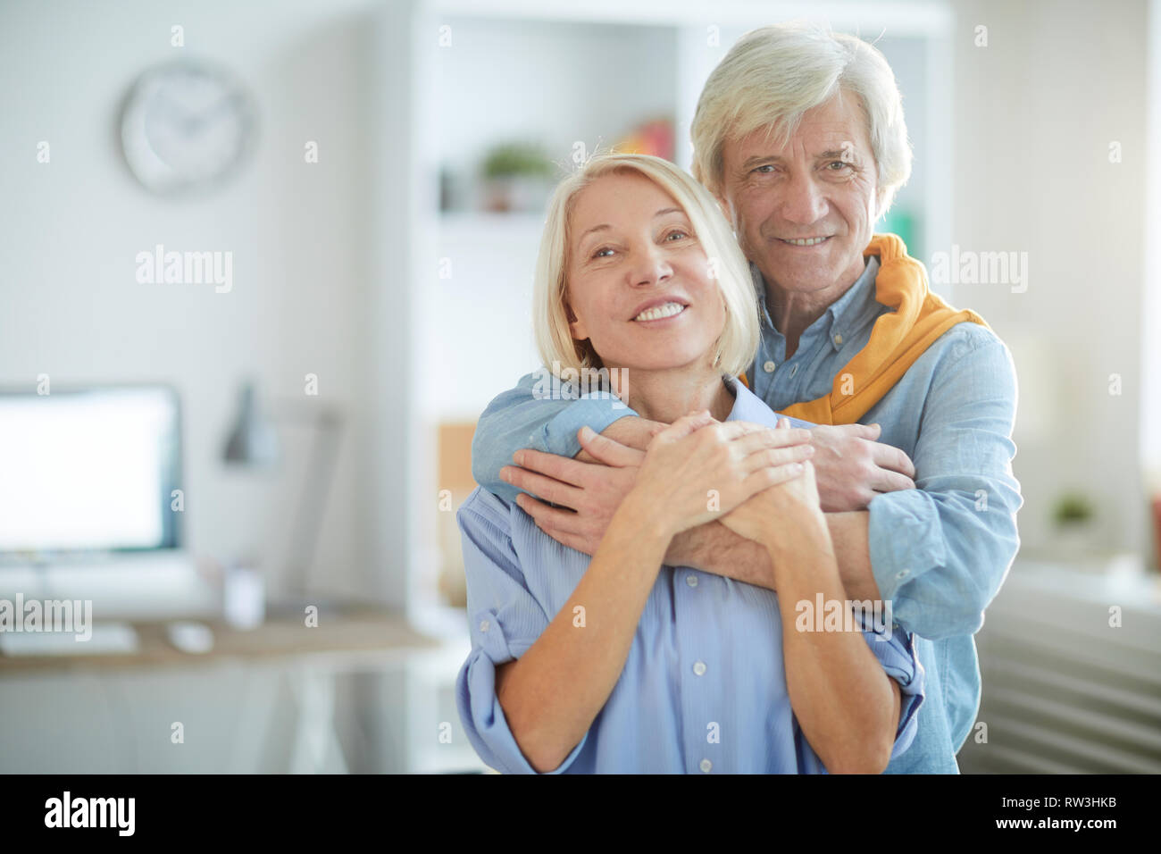 Taille portrait de senior couple embracing contemporain tendrement, copy space Banque D'Images