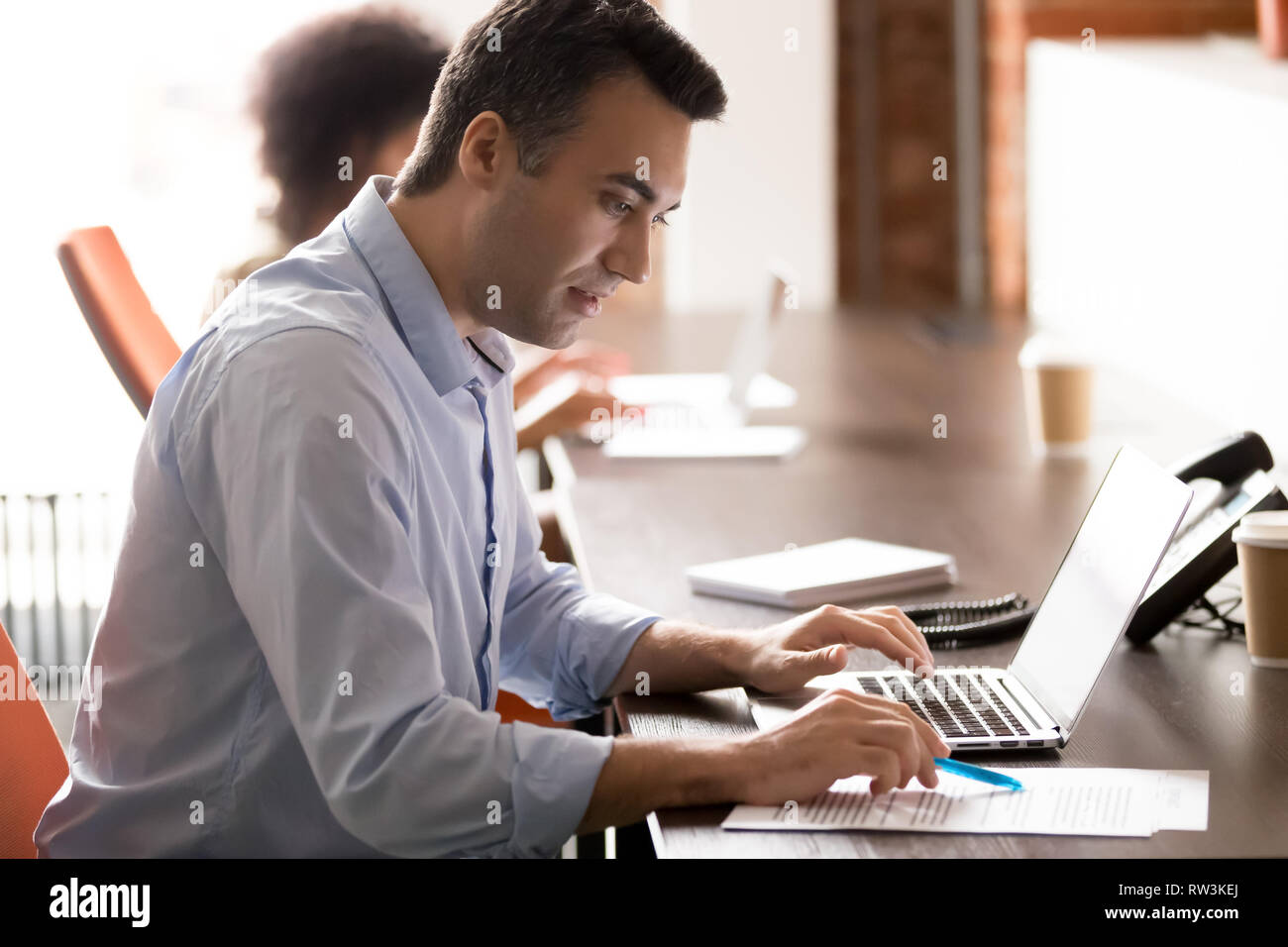 Middle-aged businessman sérieux travail avec ordinateur portable faire de la paperasserie des entreprises Banque D'Images