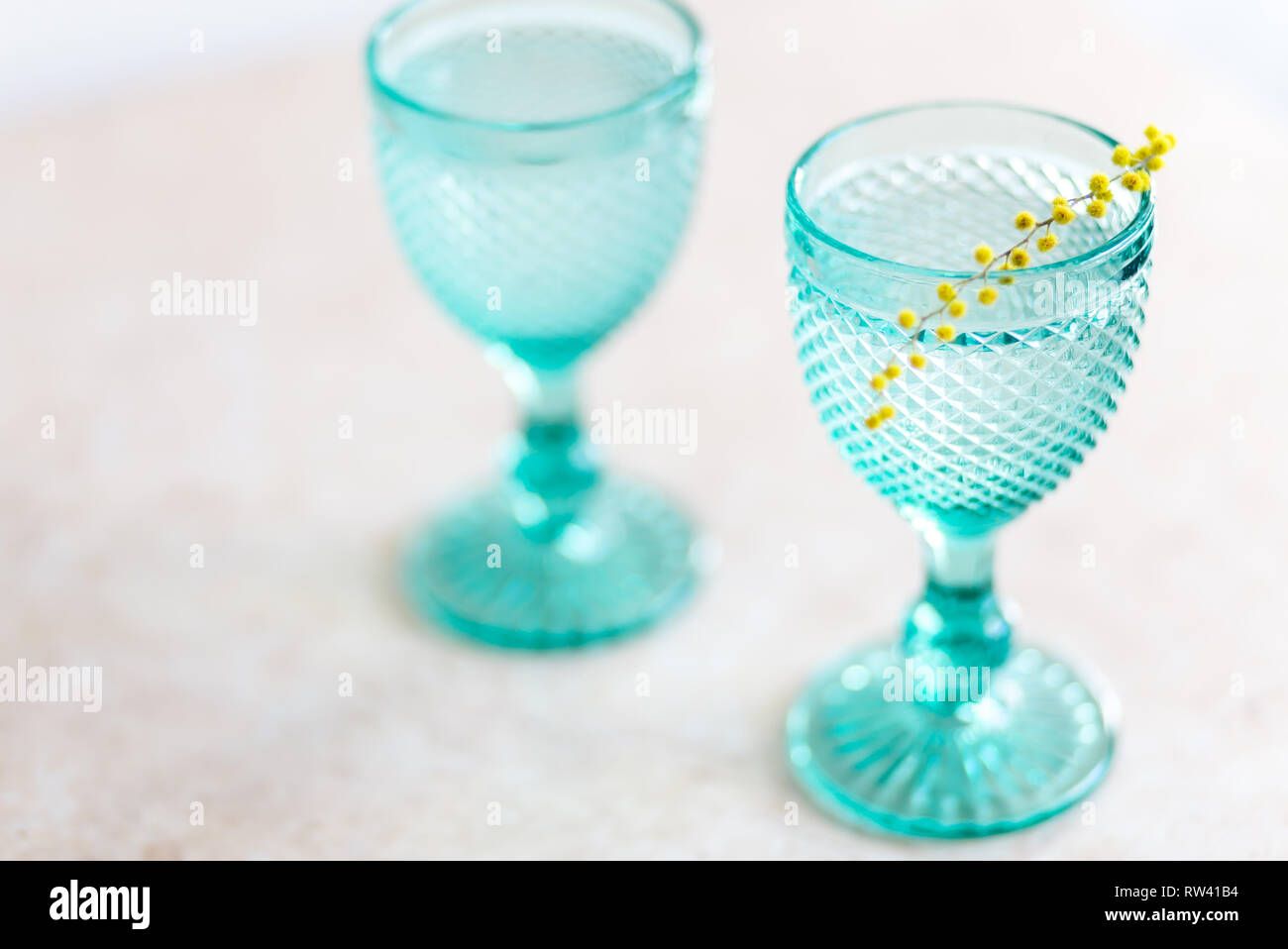 Vintage bleu jaune gobelets et mimosa . Sur l'arrière-plan. whight Wineglasses Banque D'Images