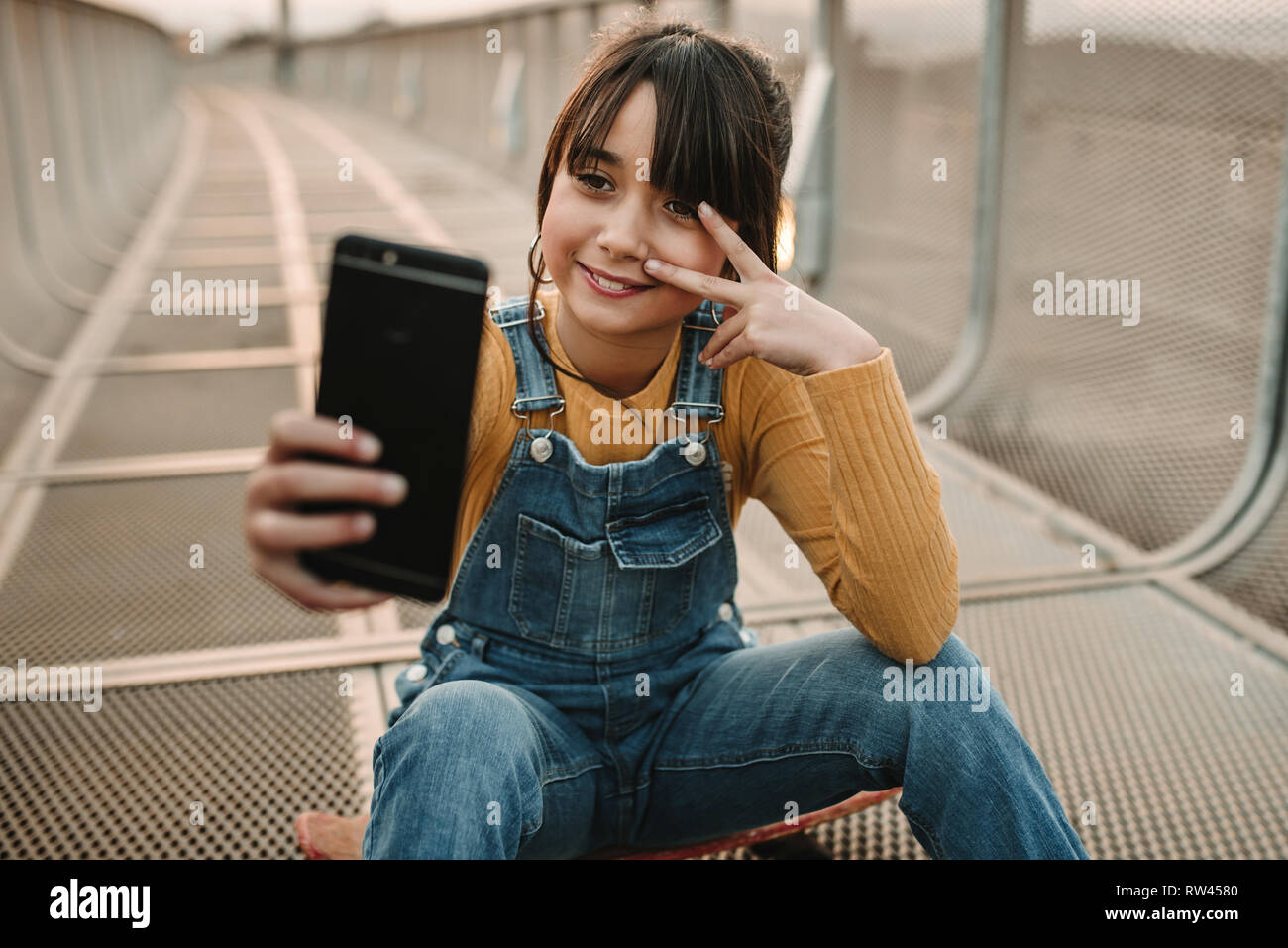 Funny Girl prenant sur smartphone dans le passage libre de selfies Banque D'Images