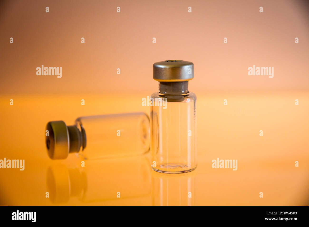 Deux bouteilles en verre sur fond orange Banque D'Images
