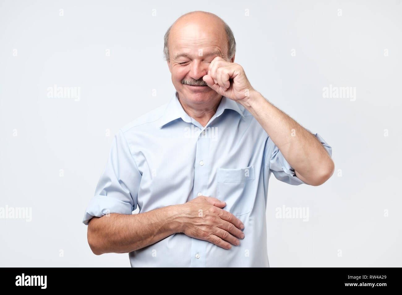 Insatisfait déconcertés senior man de pleurer et d'essuyer les larmes isolé en studio. Les gens sincères émotions, style de concept. Banque D'Images