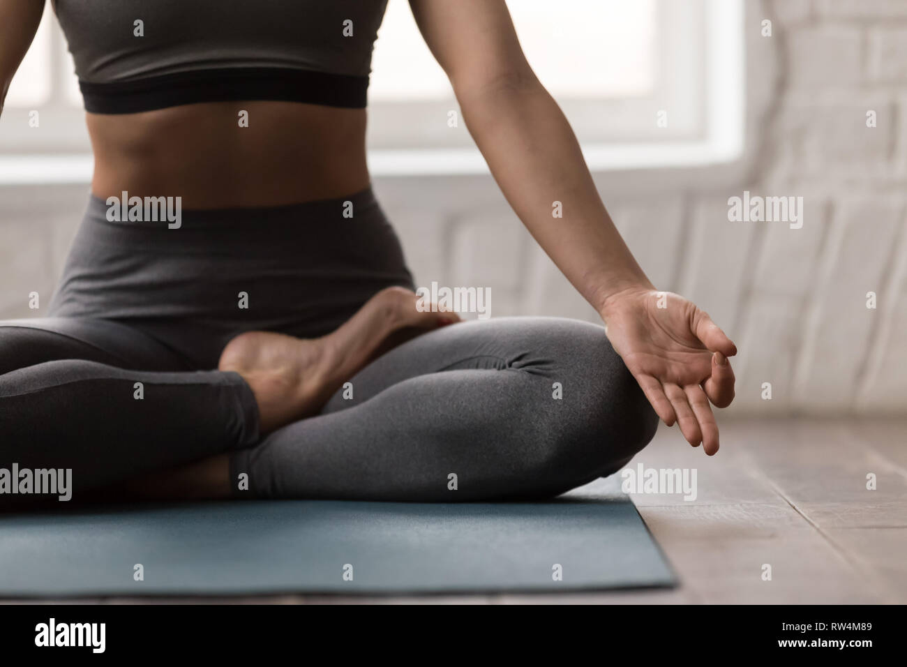 Young woman practicing yoga, assis en Padmasana, poser l'exercice Lotus Banque D'Images