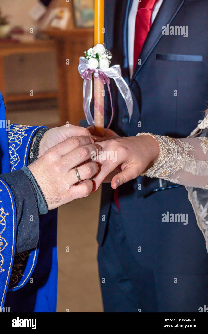 Cérémonie de mariage traditionnel dans l'Eglise orthodoxe. Prêtre mettant anneau de mariage sur mariée doigt. Close up. Banque D'Images