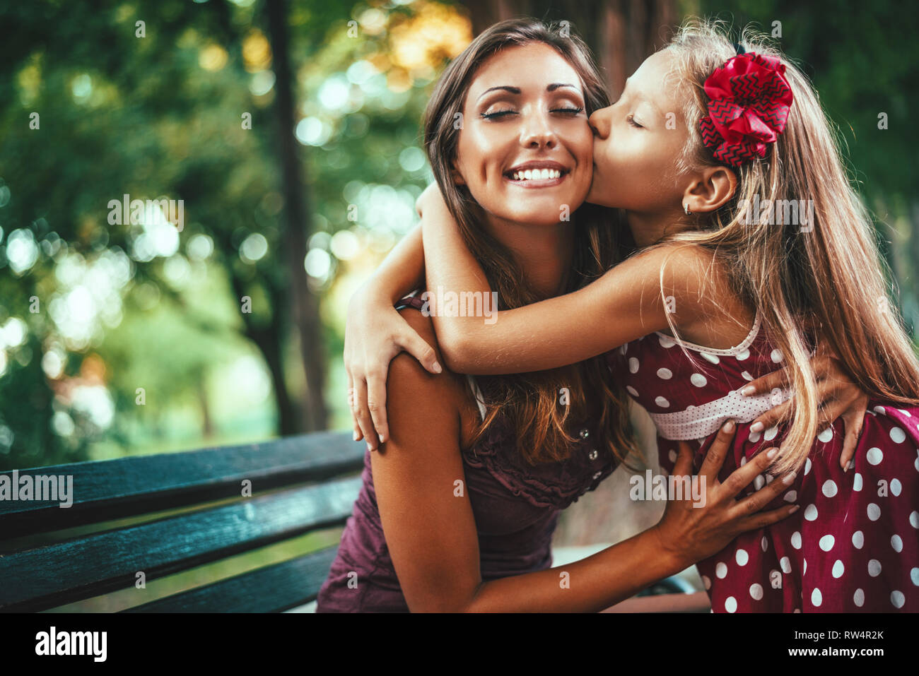 Belle Mère et fille s'amusent au parc au printemps accolades et embrassades. Banque D'Images