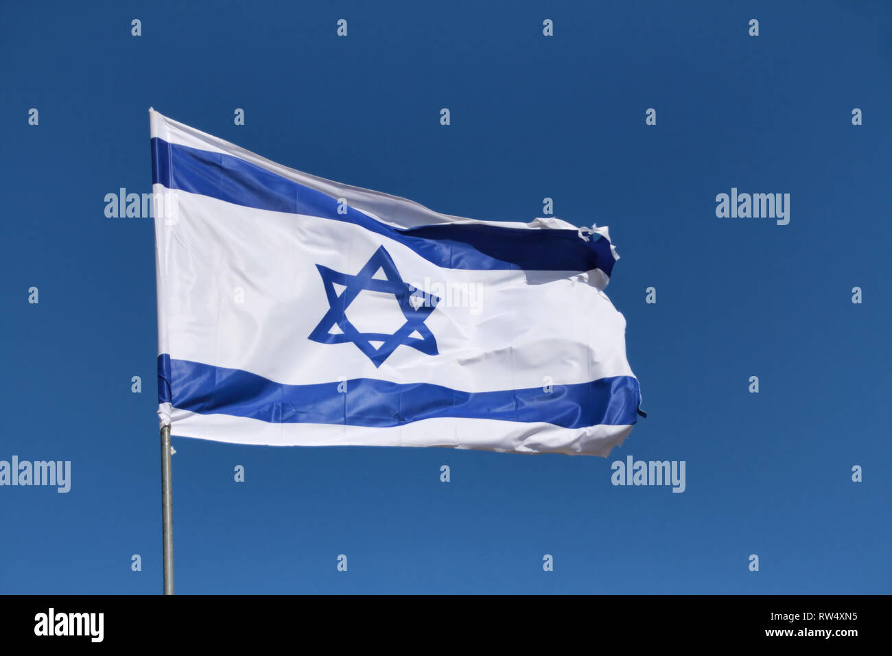 Le magen David, l'étoile de David - Israel's flag - vagues dans une forte brise contre un ciel bleu. Banque D'Images