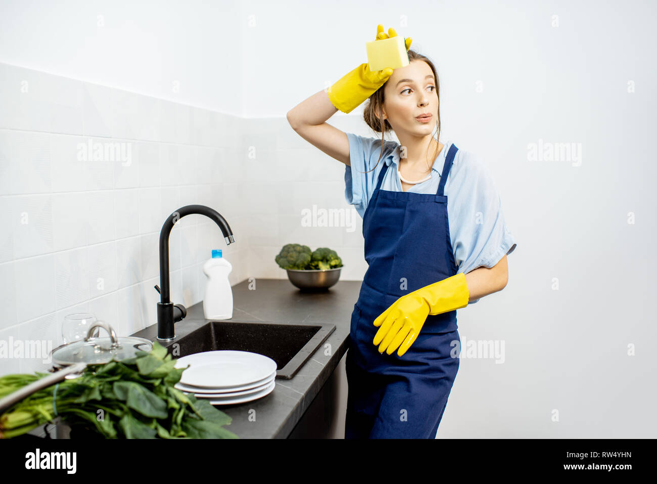 Jeune femme en tablier vaisselle sur la cuisine à la maison Photo Stock -  Alamy