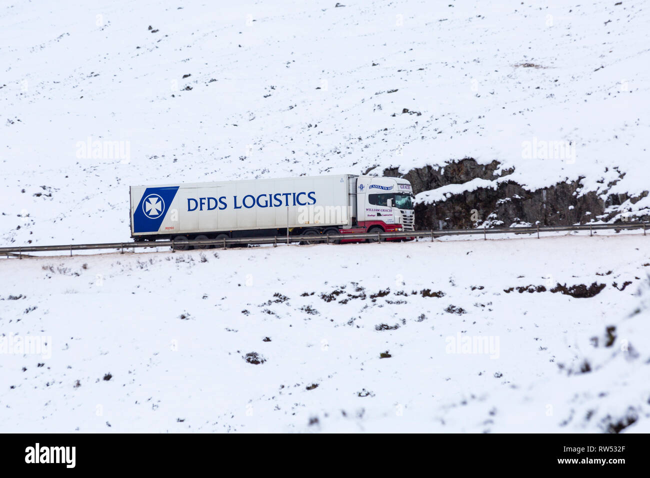 Véhicule camion logistique DFDS voyageant le long de la route A82 sur journée d'hiver avec de la neige autour de Rannoch Moor, Glencoe, Highlands, Scotland en hiver Banque D'Images